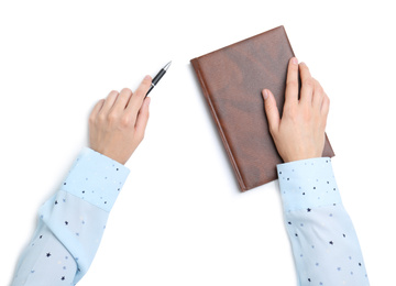 Woman holding pen and notebook on white background, top view