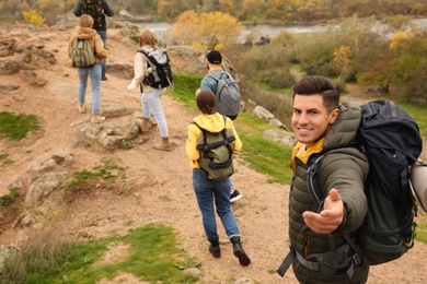 Photo of Group of hikers with backpacks climbing up mountains