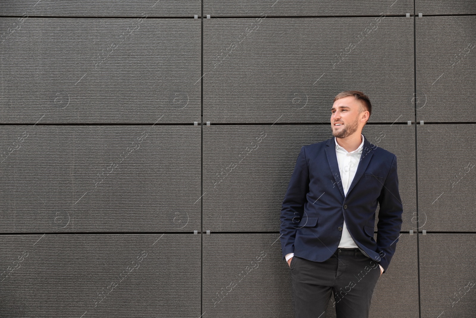 Photo of Portrait of handsome young man leaning to wall outdoors, space for text