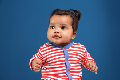 Photo of Cute African American baby on blue background