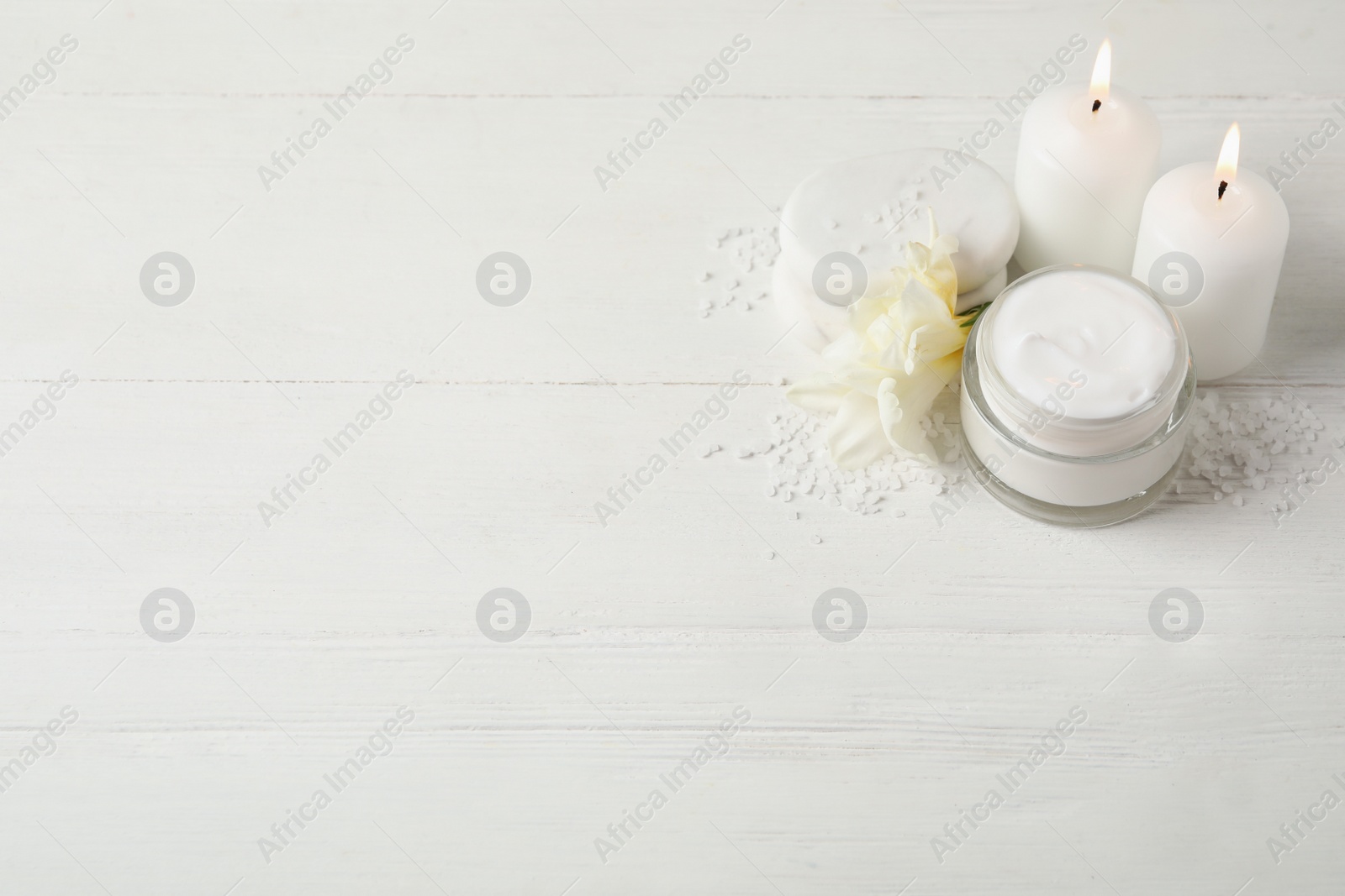 Photo of Composition with cream and spa stones on white table, space for text