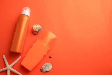 Photo of Bottles of sunscreen, seashells and starfish on coral background, flat lay. Space for text