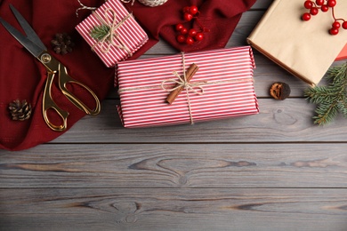 Photo of Flat lay composition with beautifully wrapped gift boxes on wooden table, space for text