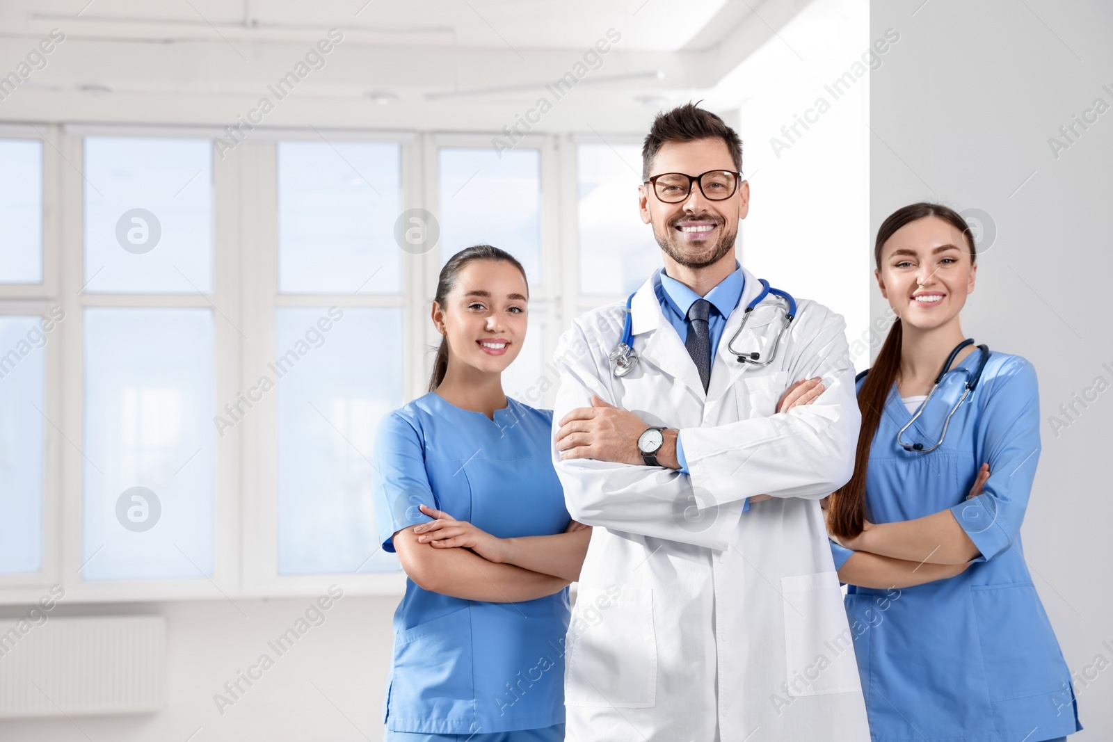 Photo of Team of professional doctors in clinic hallway, space for text