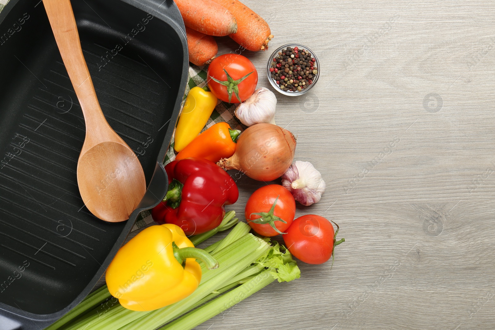 Photo of Black pot, spoon and fresh products on wooden table, top view. Space for text