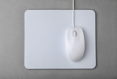 Photo of Wired computer mouse and pad on grey background, flat lay