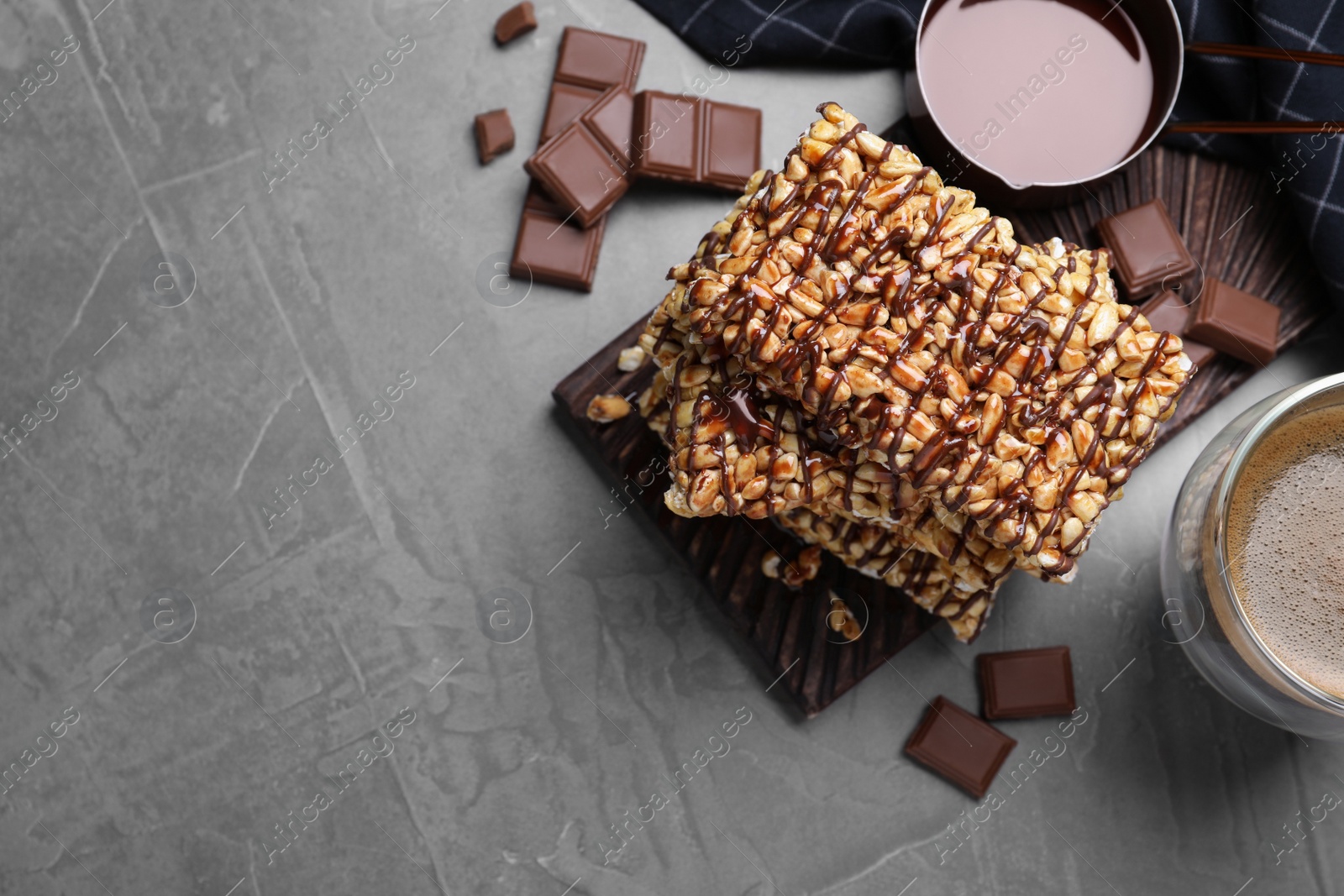 Photo of Delicious rice crispy treats on grey table, flat lay. Space for text