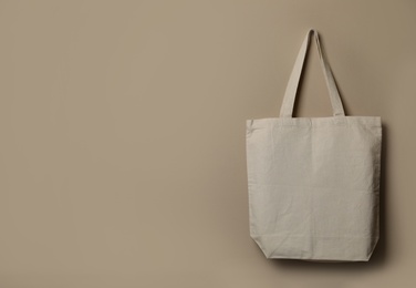 Photo of Eco tote bag hanging on color wall. Space for design