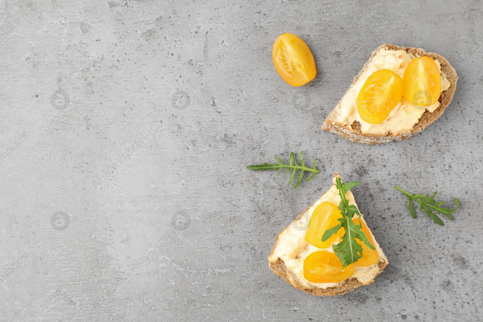 Photo of Tasty fresh tomato bruschettas on grey table, flat lay. Space for text