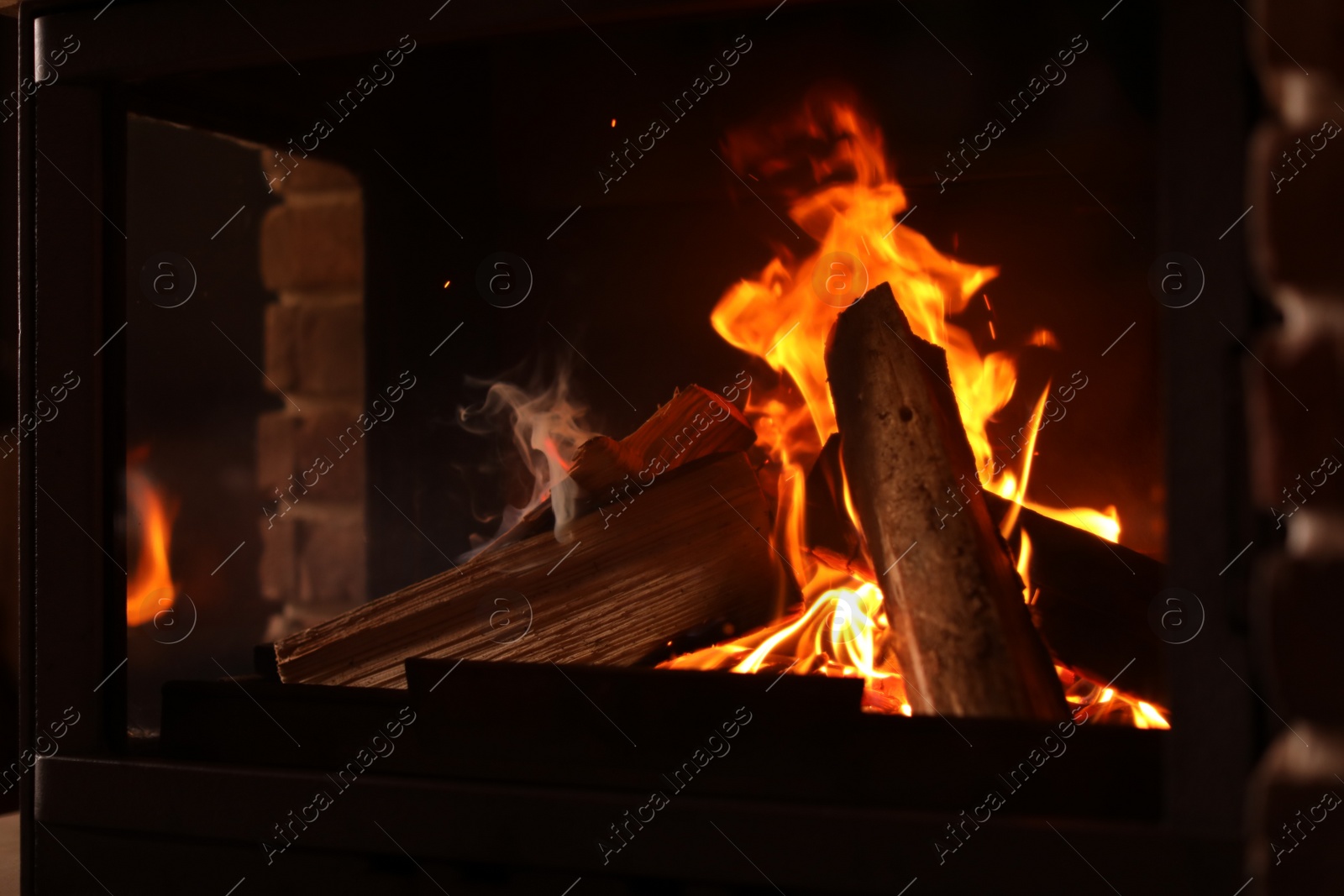 Photo of Fireplace with burning wood, closeup view. Winter vacation