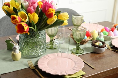 Photo of Easter celebration. Festive table setting with beautiful flowers and painted eggs
