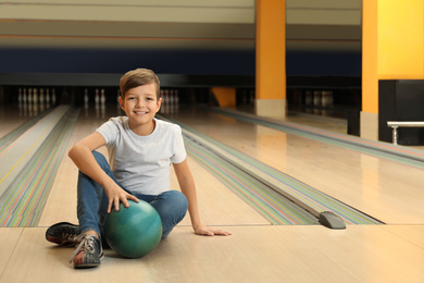 Photo of Preteen boy with ball in bowling club