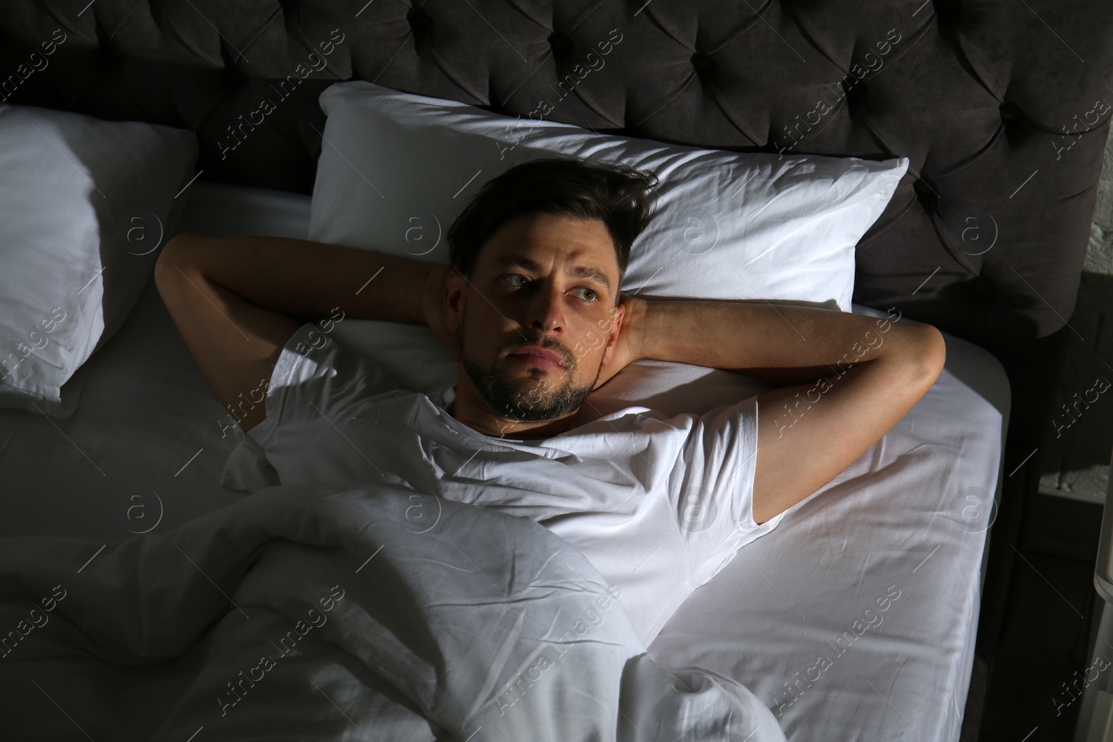 Photo of Man suffering from insomnia in bed at home