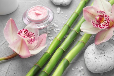 Photo of Composition with bamboo branches and flowers on light background