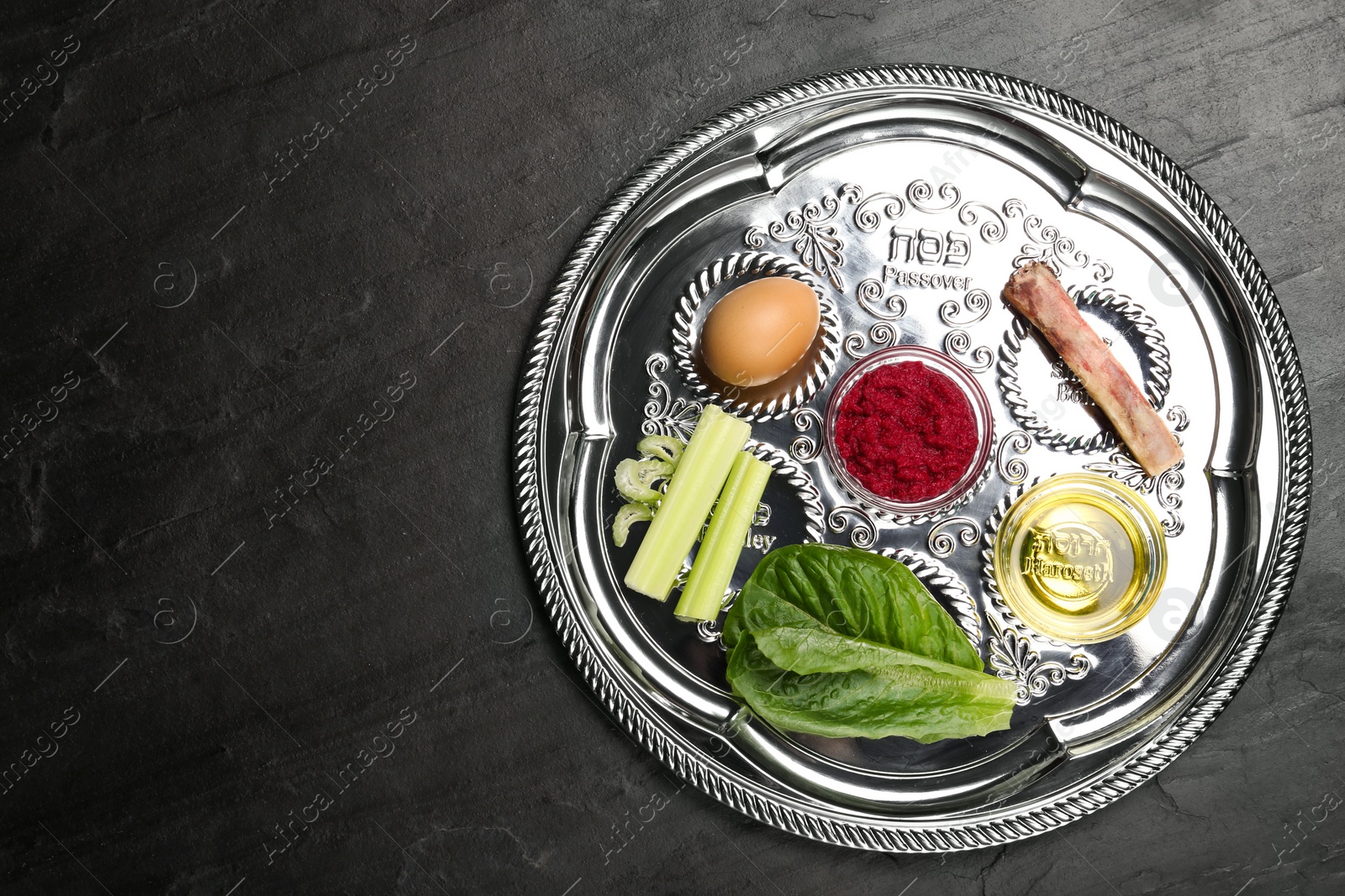 Photo of Passover Seder plate (keara) on black table, top view with space for text. Pesah celebration