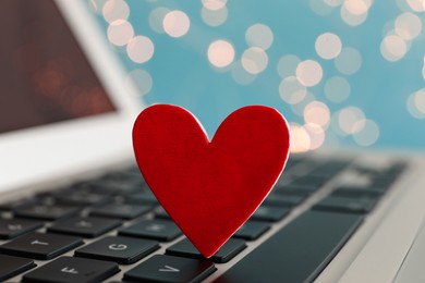 Photo of Decorative heart on laptop keyboard, closeup. Online dating concept