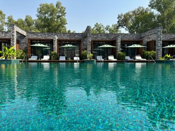 Swimming pool, exotic plants, umbrellas and sunbeds at luxury resort
