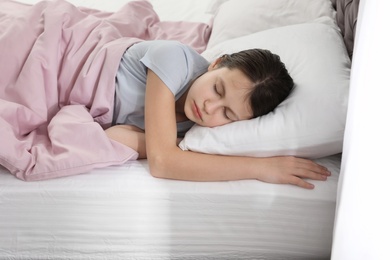 Beautiful little girl sleeping in bed at home