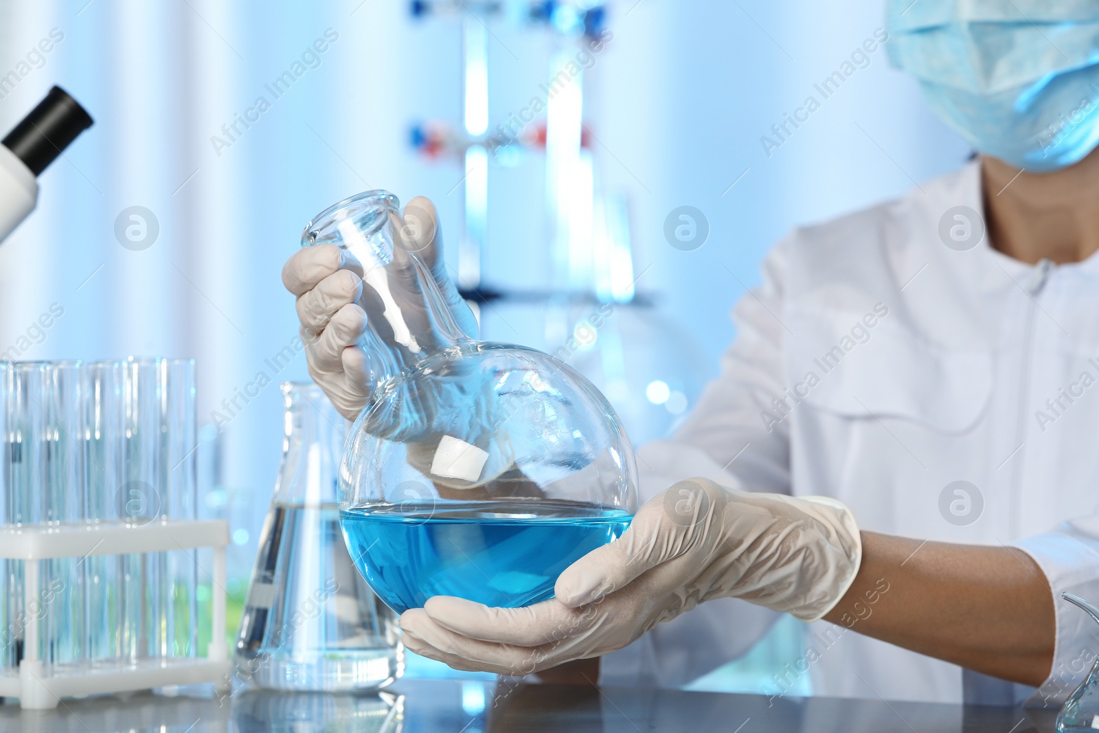 Photo of Doctor holding Florence flask with blue liquid, closeup. Laboratory analysis