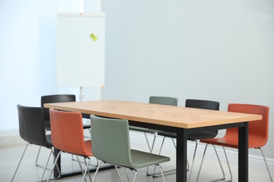 Conference room interior with wooden table and flipchart