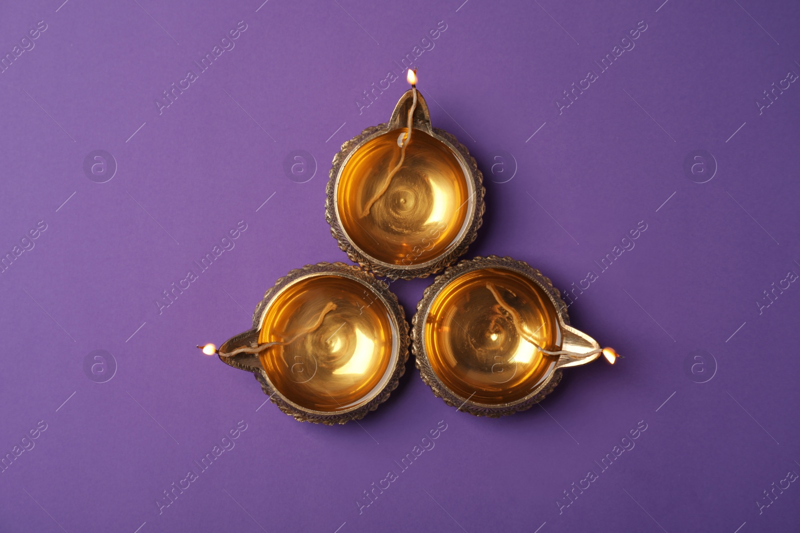 Photo of Diwali diyas or clay lamps on color background, top view