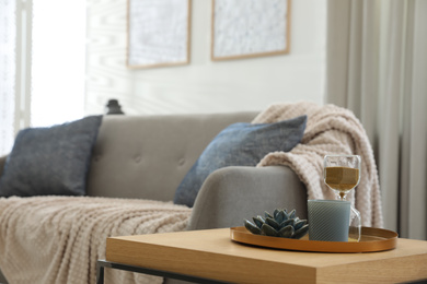 Photo of Table with decor near sofa indoors. Interior design