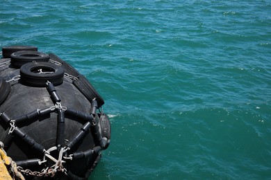Photo of Black floating fender in sea on sunny day