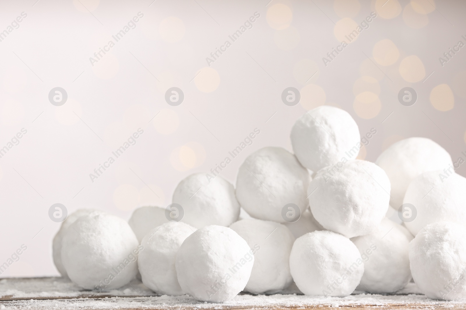 Photo of Snowballs on table against blurred lights, space for text