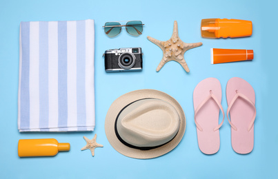 Flat lay composition with beach objects on light blue background