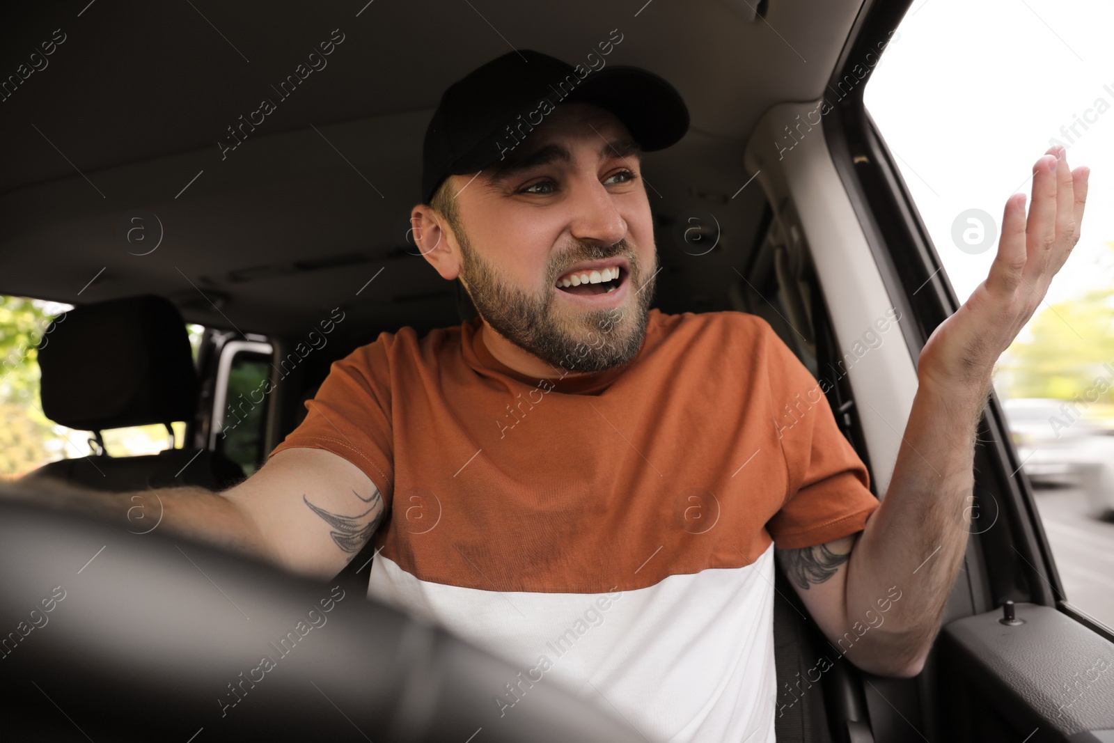 Photo of Emotional man in car. Aggressive driving behavior