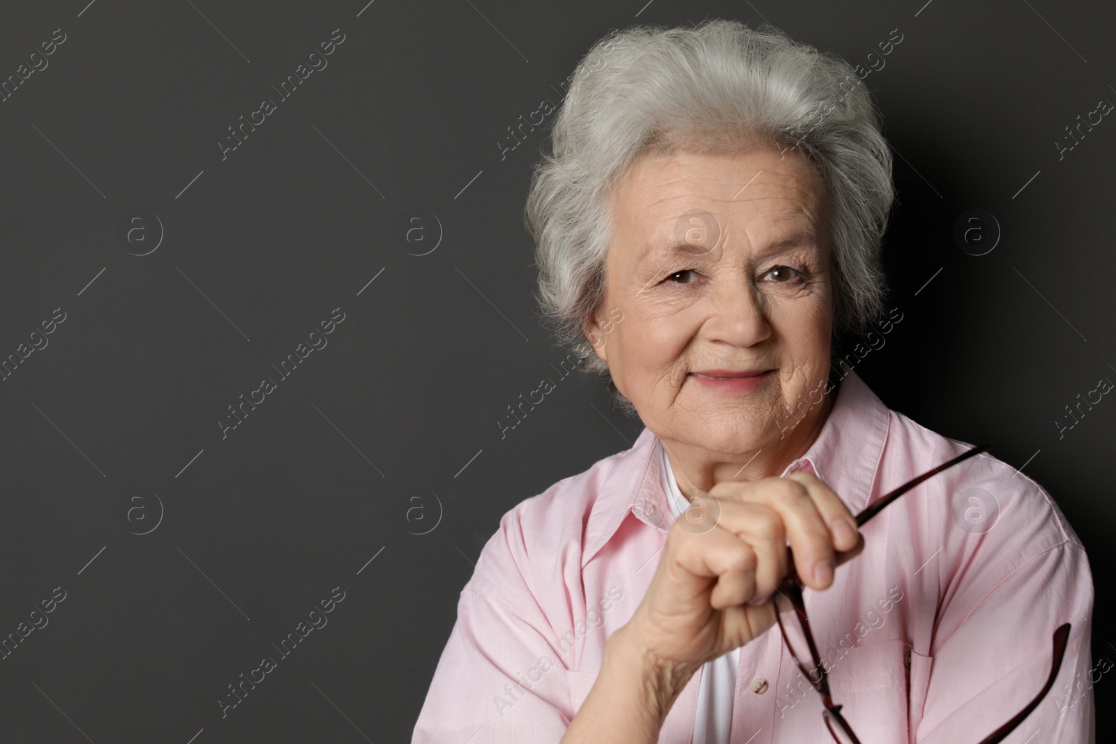 Photo of Portrait of mature woman on black background. Space for text