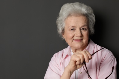 Portrait of mature woman on black background. Space for text