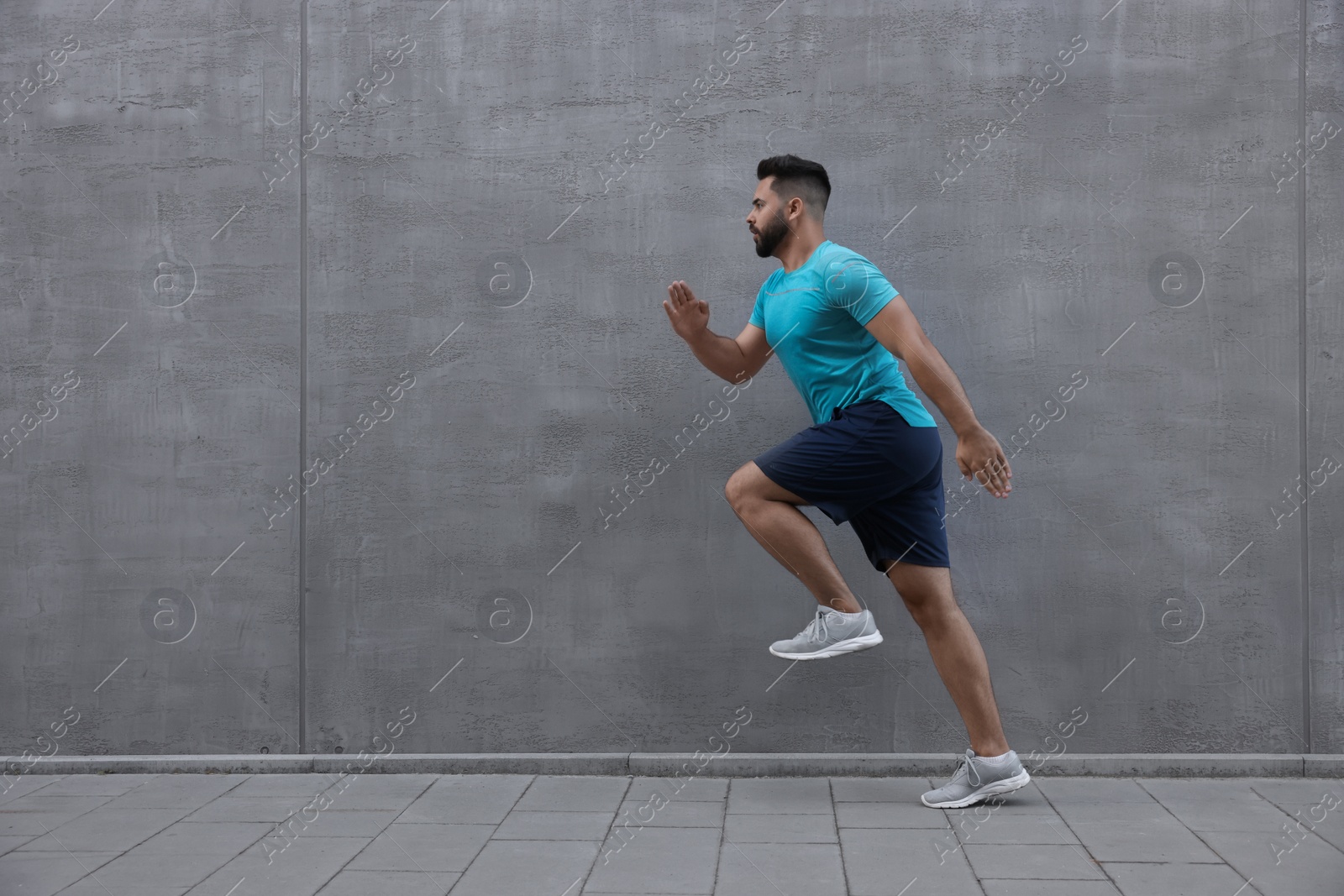 Photo of Young man running near building outdoors. Space for text