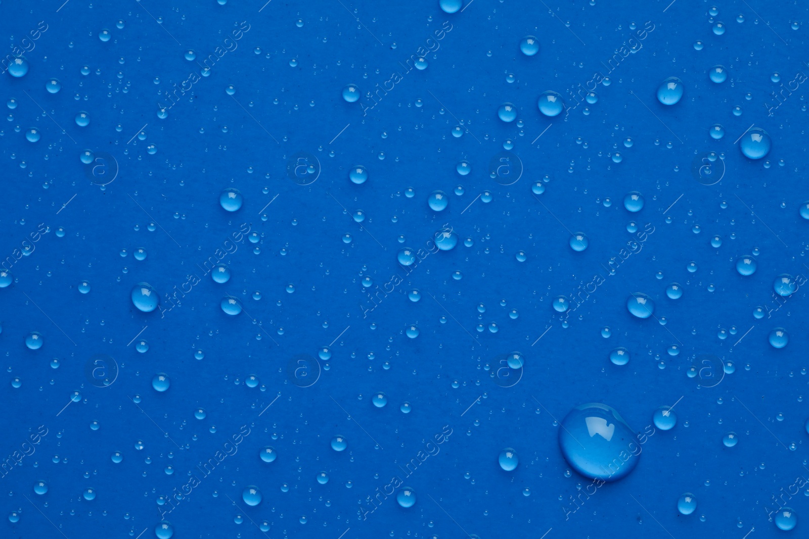 Photo of Water drops on blue background, top view