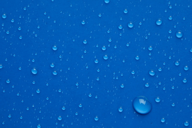 Photo of Water drops on blue background, top view