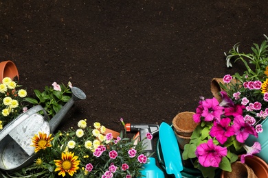 Photo of Flat lay composition with gardening equipment and flowers on soil, space for text