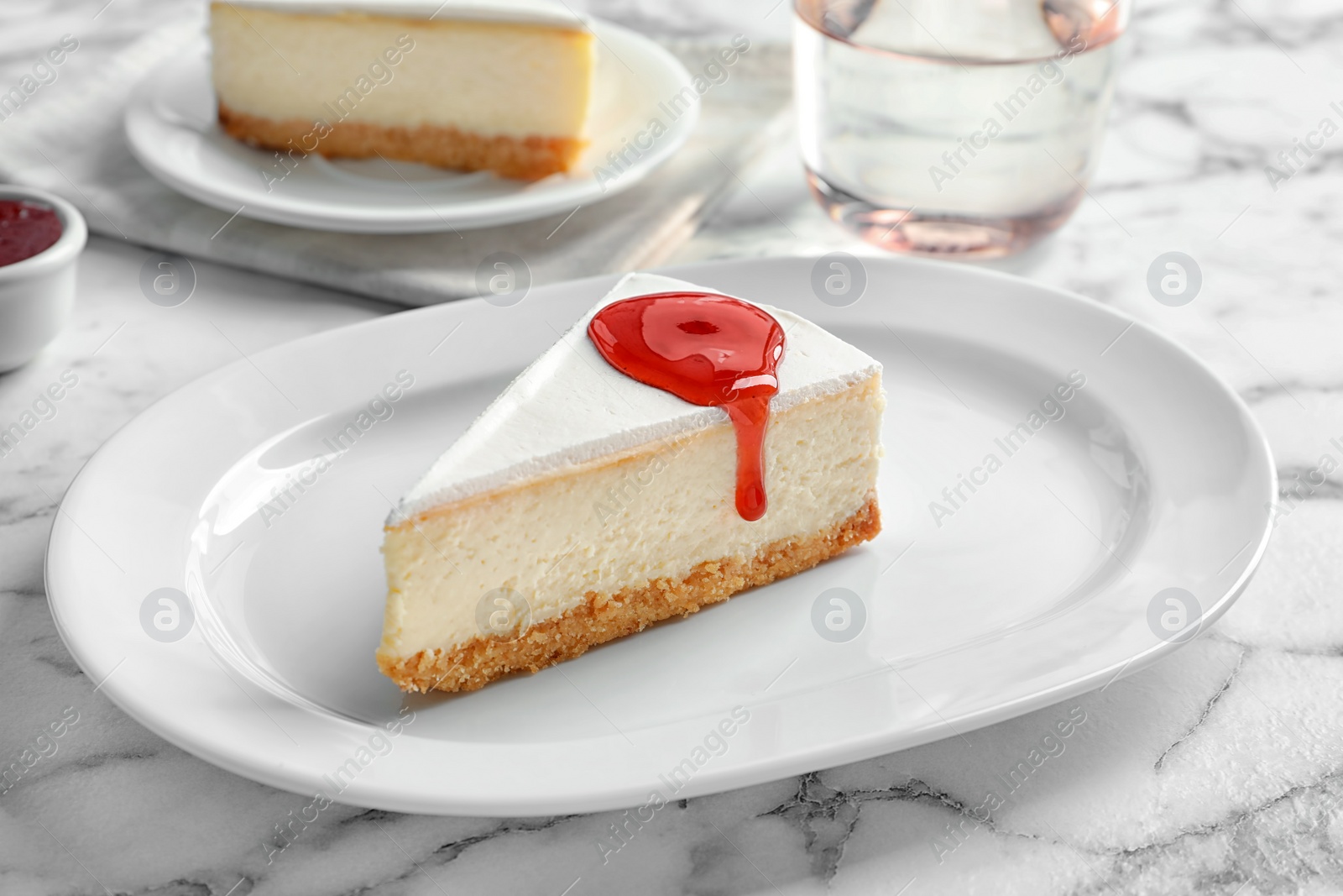 Photo of Delicious cheesecake served with sweet jam on plate