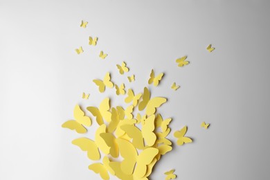 Yellow paper butterflies on white background, top view