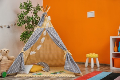 Photo of Cozy kids room interior with play tent and toys