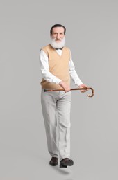 Photo of Senior man with walking cane on light gray background