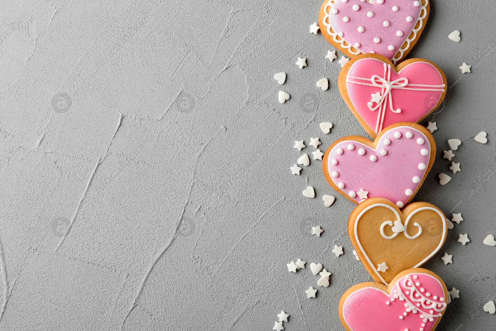 Photo of Flat lay composition with decorated heart shaped cookies and space for text on table