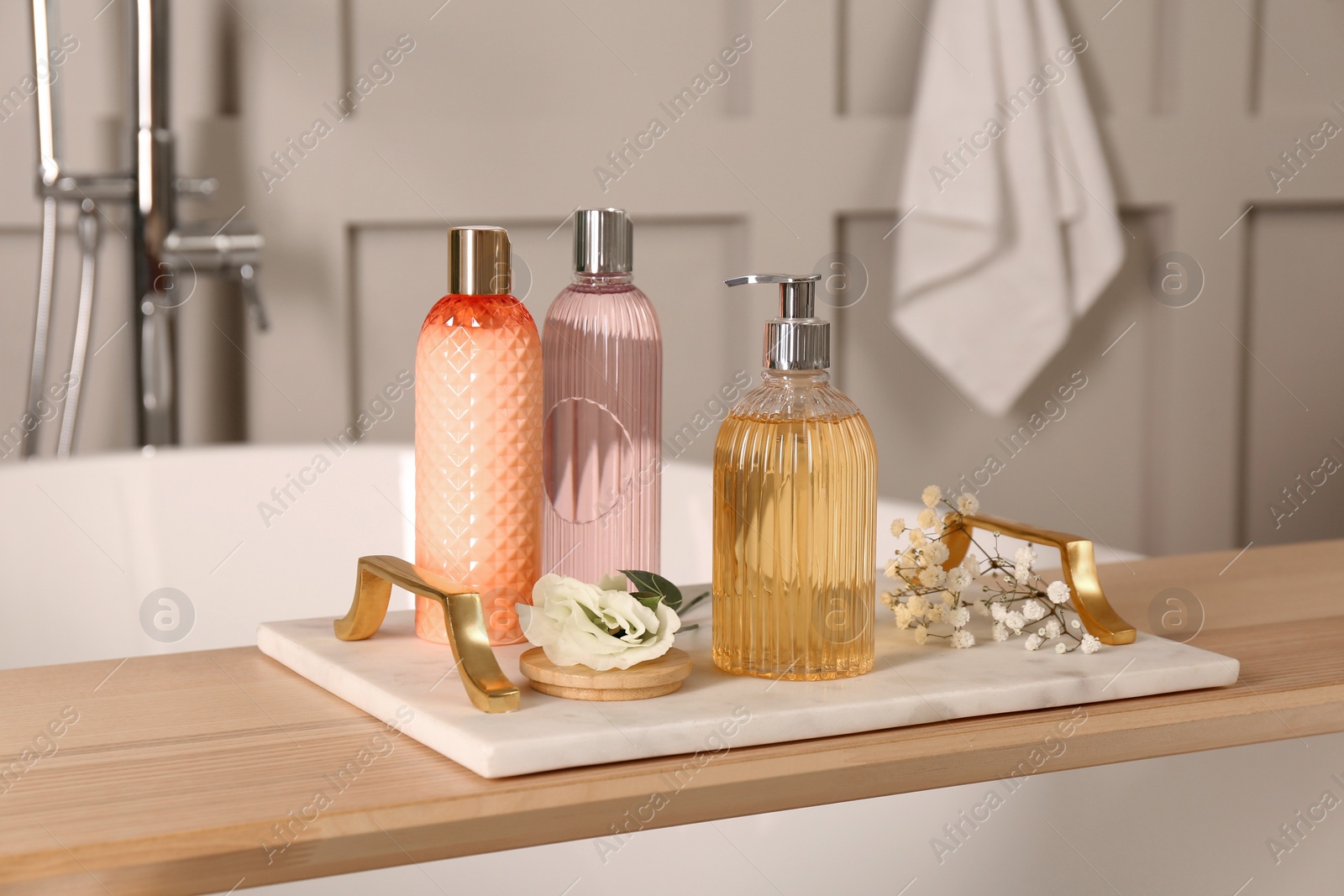 Photo of Liquid soap and other toiletries on wooden table in bathroom