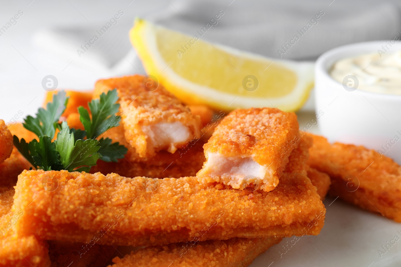 Photo of Tasty fresh fish fingers on white board, closeup
