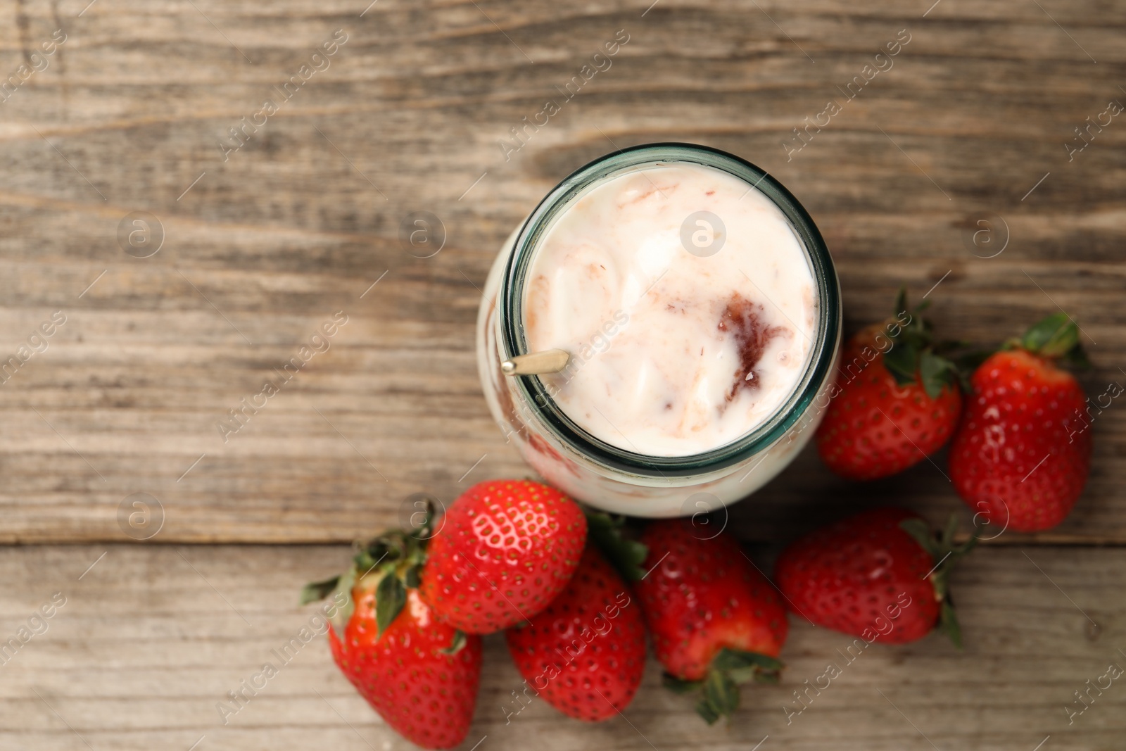 Photo of Tasty yoghurt with jam and strawberries on wooden table, top view. Space for text