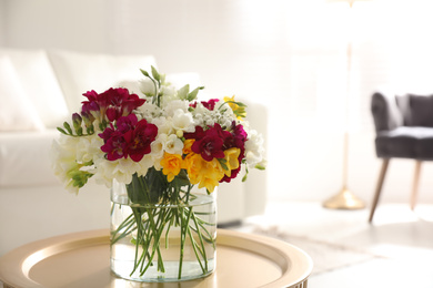 Photo of Beautiful bouquet with spring freesia flowers in light room, space for text