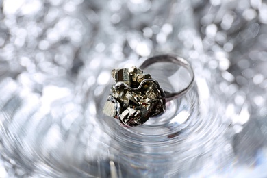 Photo of Beautiful silver ring with pyrite gemstones on textured surface, closeup