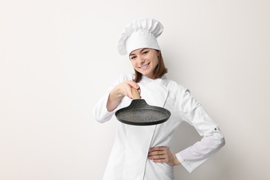 Photo of Professional chef with frying pan on light background