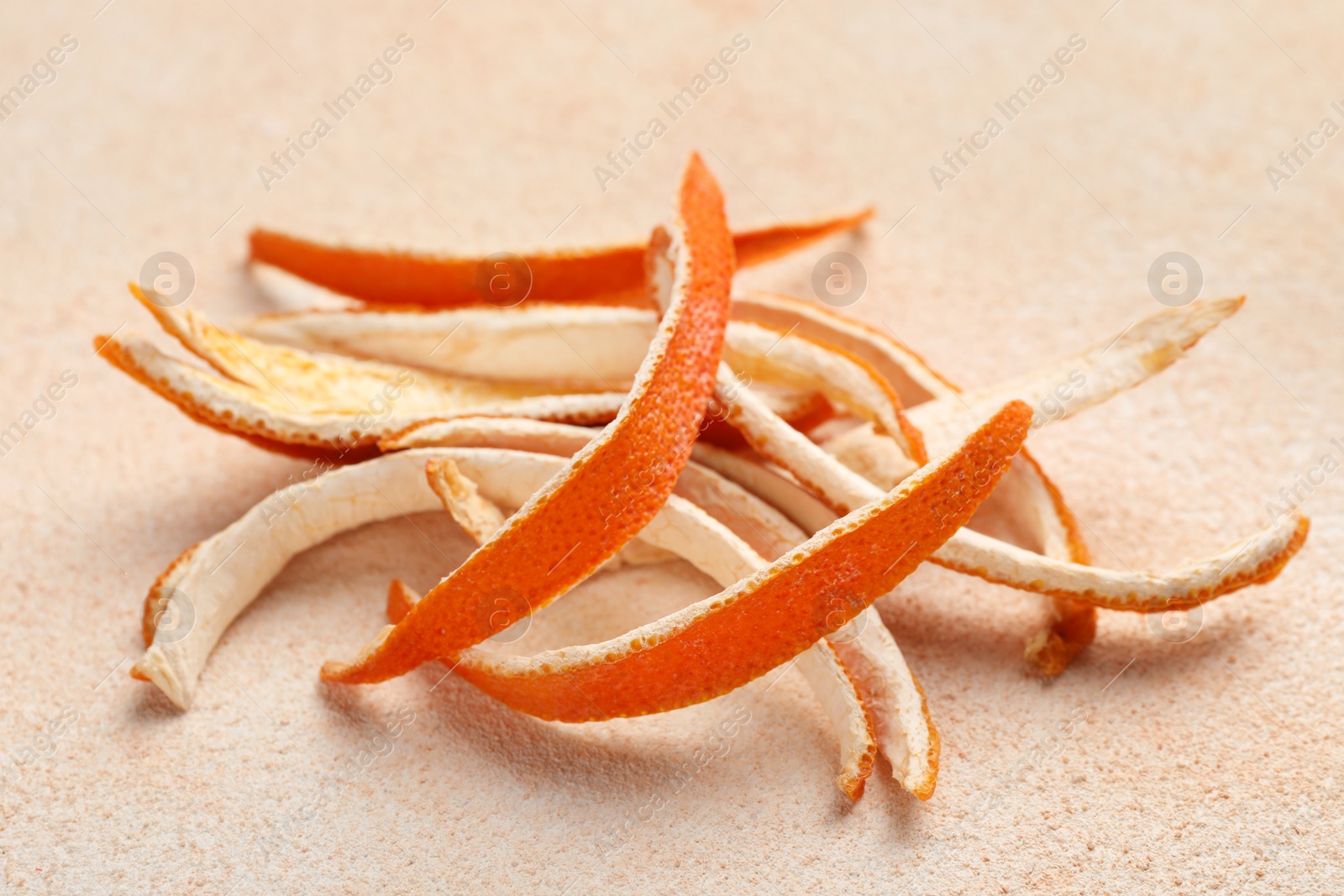 Photo of Dry orange peels on beige table, closeup