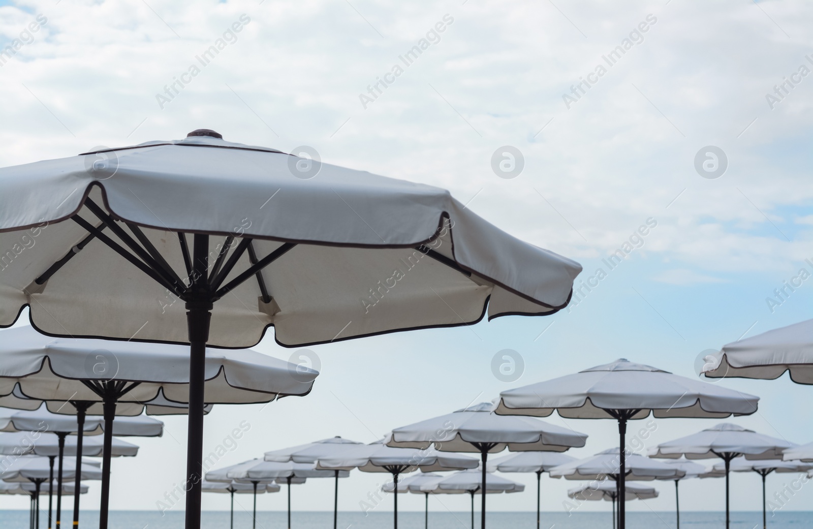 Photo of Beautiful white beach umbrellas against blue sky