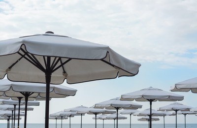 Beautiful white beach umbrellas against blue sky